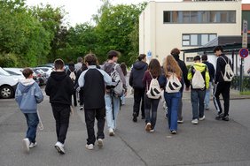 Schüler:innen gehen über den Parkplatz des Landratsamtes.